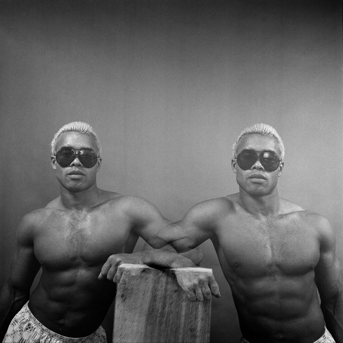 Black and white photograph of two black men with bleached blonde hair and wearing black sunglasses