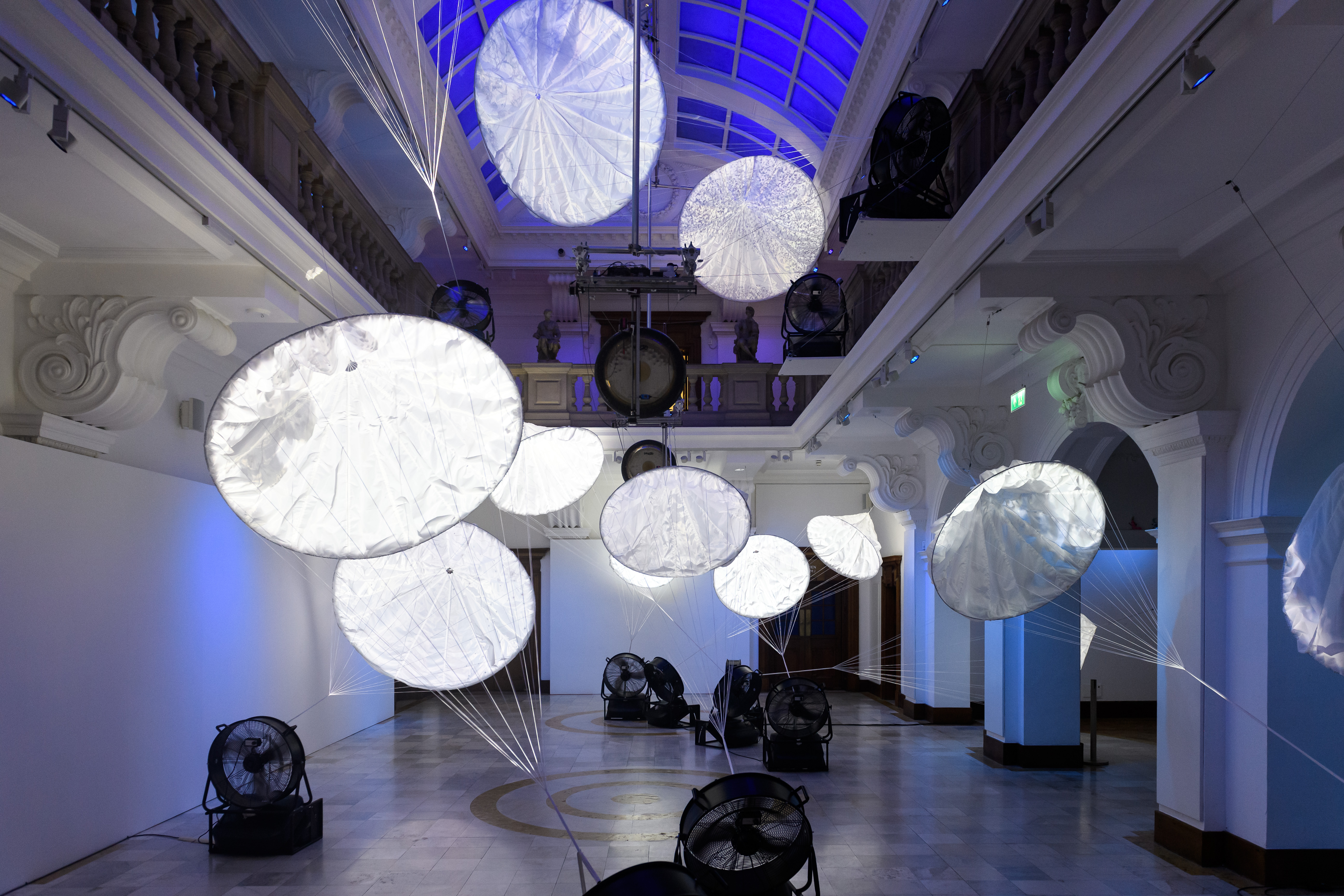 Image of an install shots with white structures floating in space against a blue background