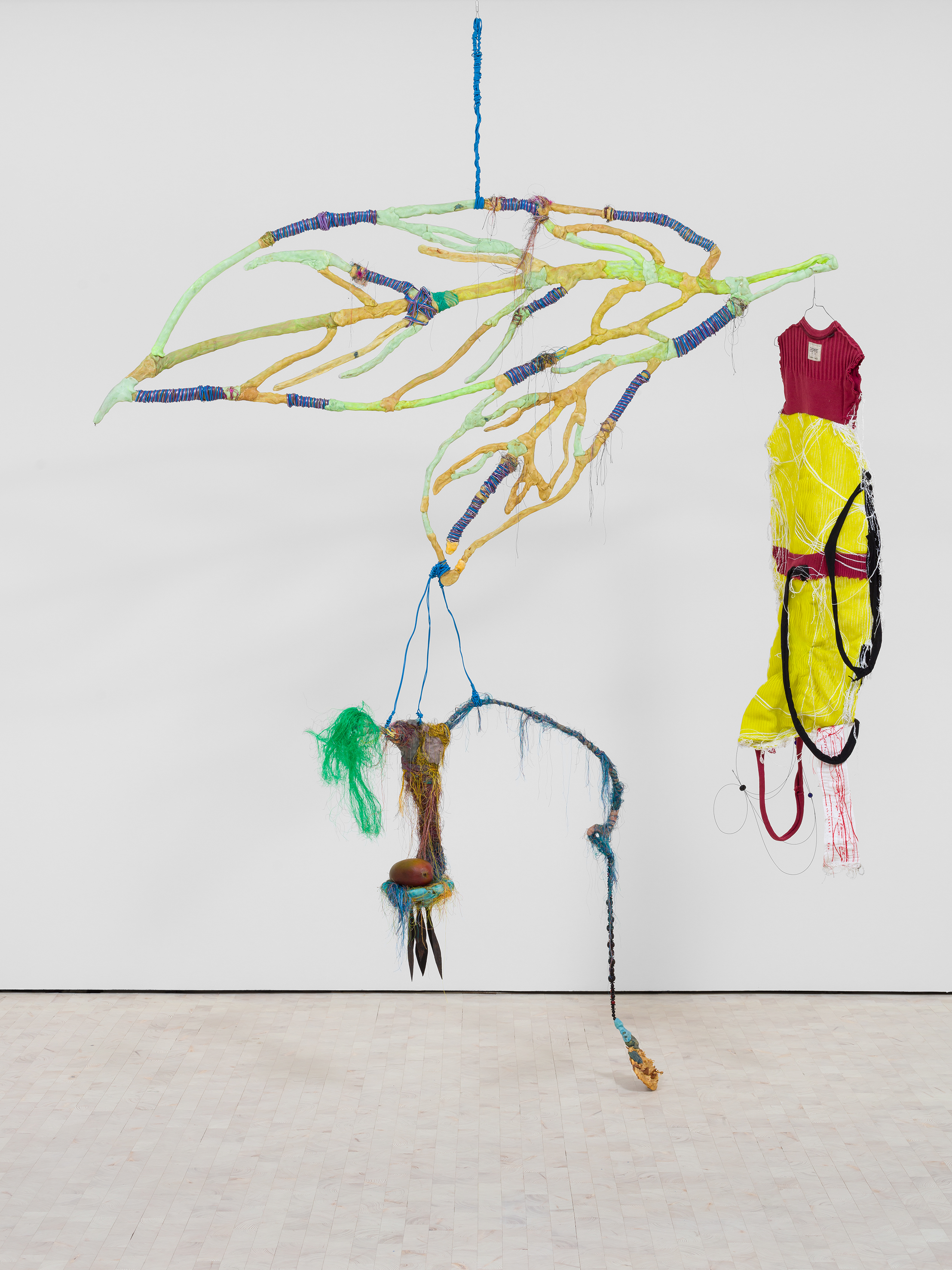 Julien Creuzet, 'Dans nos yeux, words come from far away, from my ancestral memory, astral, sky, I’m not alone on the way anymore (rouge et jaune)', 2020-2024. Steel object, electrical wires, clothes, pearls, plastic, threads, steel, acrylic and fresh mango. © Julien Creuzet. Courtesy the artist; Andrew Kreps Gallery, New York and Stephen Friedman Gallery, London and New York. Photo by Mark Blower.