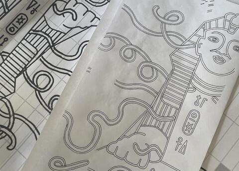 Several drawings on paper of the proposed commission design by artist James Lambert depicting an ancient Egyptian sphynx drawn in a graphic cartoon style accompanied by curling lines in the background and foreground