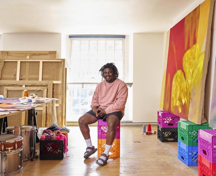 Alvaro Barrington in his studio surrounded by colourful boxes